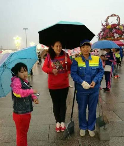 游客为环卫工打伞